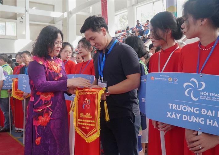 Thứ trưởng Bộ GD&ĐT Ngô Thị Minh tặng cờ lưu niệm cho các đơn vị tham gia Hội thao.
