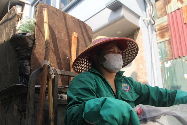 Đầu giờ chiều, chị Nguyễn Thị Thuận ( 46 tuổi, quận Hoàng Mai) một ( nhân viên Hợp tác xã Thành Công) đang bắt đầu công việc của mình 3h-11h. Dọn dẹp vệ sinh, trên con ngõ Bùi Xương Trạch, từng nhà, từng ngõ, vào thời điểm oi bức nhất trong ngày.
