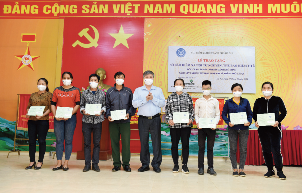 Giám đốc BHXH thành phố Hà Nội Nguyễn Đức Hòa tặng sổ BHXH tự nguyện cho người dân có hoàn cảnh khó khăn tại huyện Ba Vì.